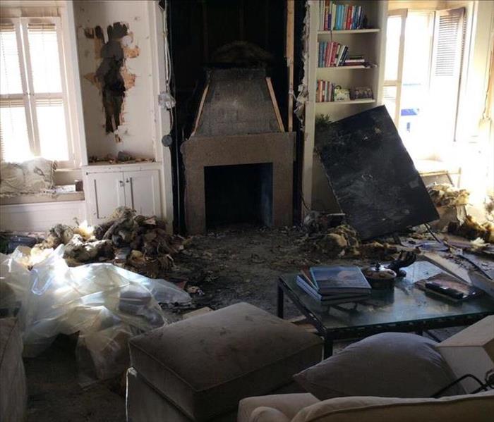 living room with debris on floor from house fire