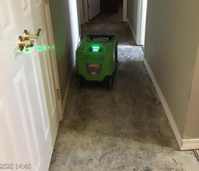hallway with flooring removed and SERVPRO equipment present 