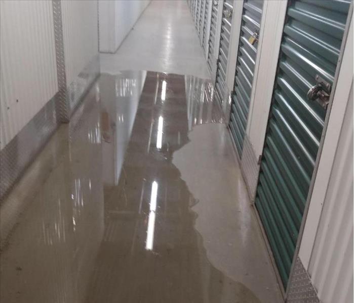 Storage unit hallway with puddle of water on the floor