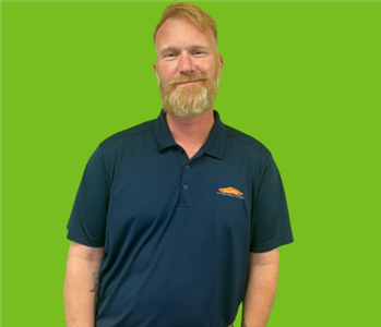 male SERVPRO employee on a green background