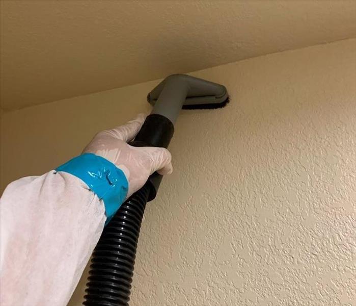 Man cleaning wall with a vacuum 