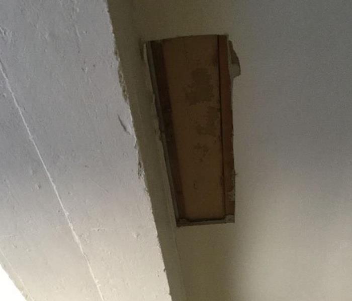 piece of ceiling cut out with water stain showing through