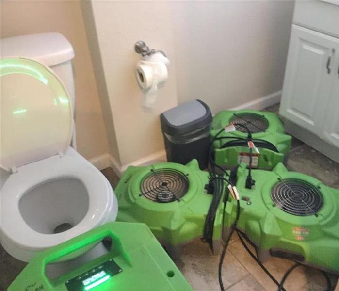toilet with fans and dehumidifiers around it