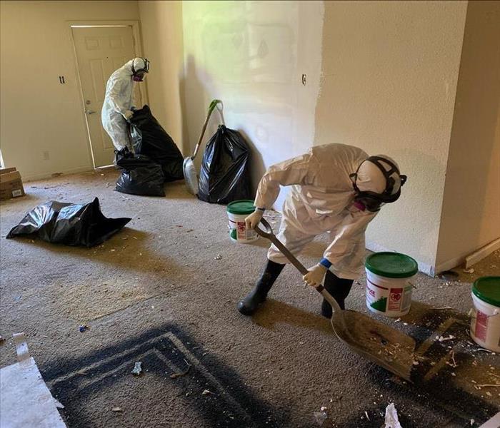 two male SERVPRO employees cleaning up fire debris