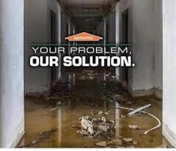 Flooded hallway with SERVPRO® house logo.