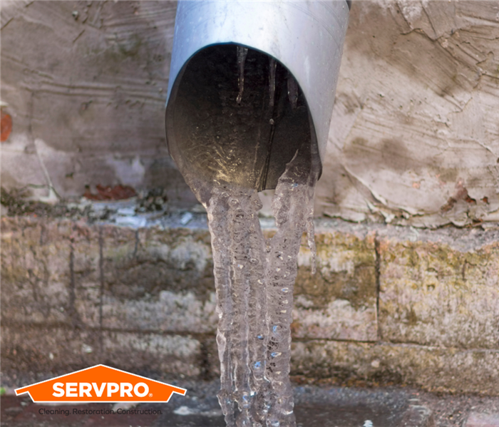 Ice coming from pipe on home with SERVPRO logo in corner