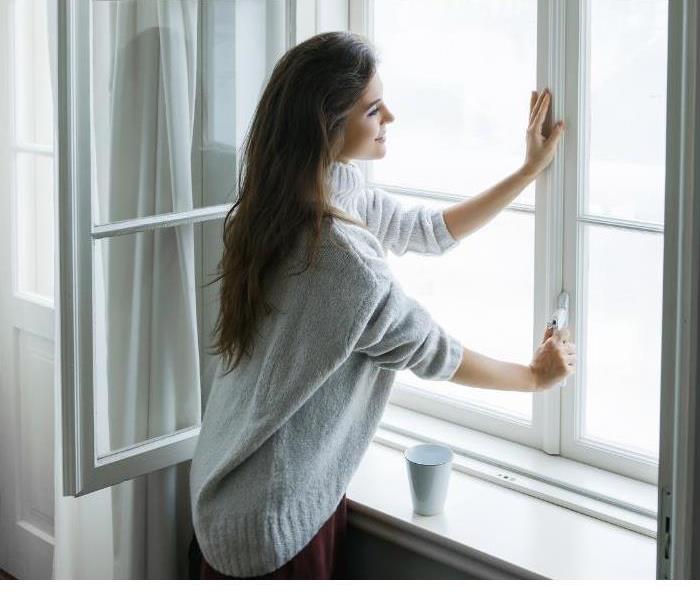 Woman standing near window in home