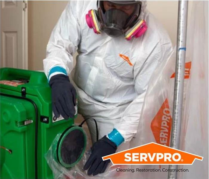Male SERVPRO employee in PPE using SERVPRO equiptment 