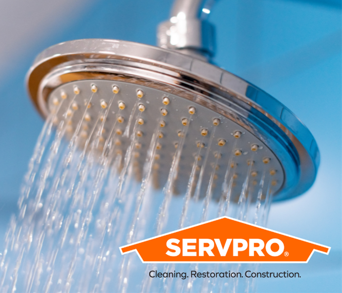 Showerhead with water running behind SERVPRO logo