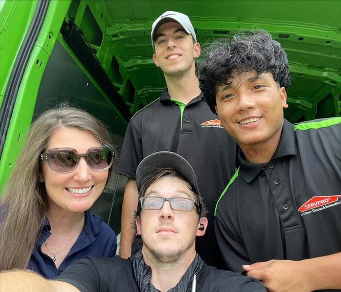 Kacey, John, Chino, and Jordan in front of SERVPRO van