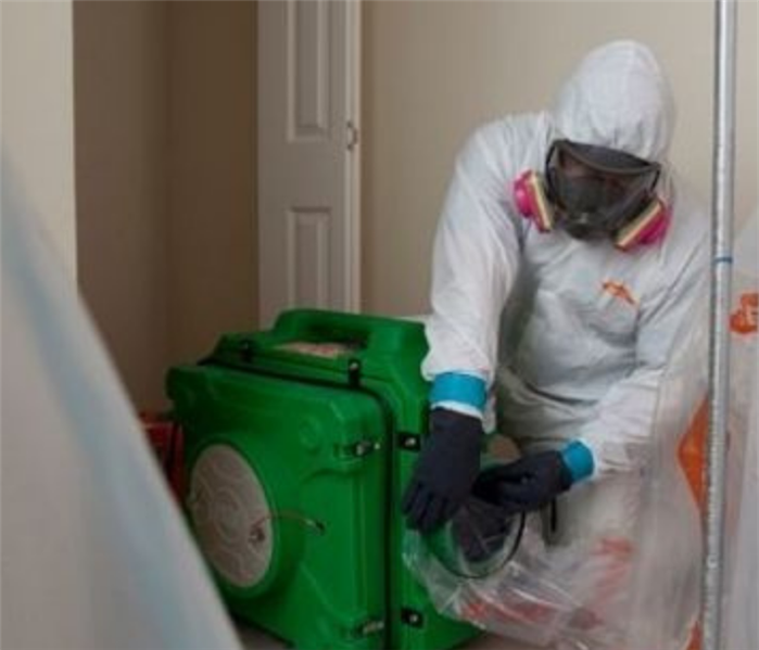 SERVPRO employee in PPE handling an airscrubber